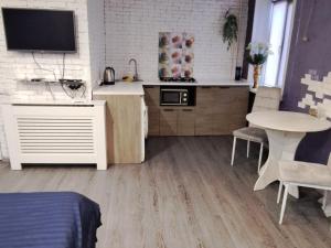 a living room with a kitchen and a table and a kitchen at Студия в центре города in Kryvyi Rih