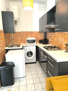 una cucina con lavatrice e lavatrice di Le Rodrigues - plages - parking - clim - wifi a Saint-Gilles-les Bains Altre 6 foto