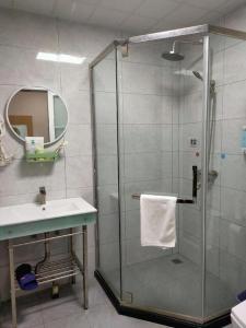 een badkamer met een glazen douche en een wastafel bij 7 Days Inn·Taixing Wenchang Road in Taixing