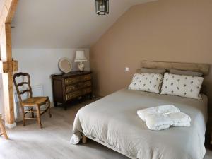 een slaapkamer met een bed met 2 kussens en een stoel bij Ker Loal 