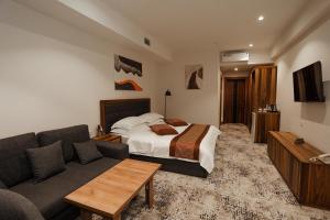a hotel room with a bed and a couch at Bogishamol Hotel in Andijan