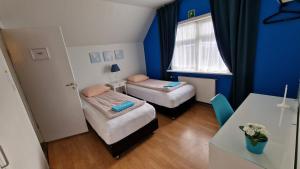 Una pequeña habitación con dos camas y una mesa. en Grundarfjördur Hostel, en Grundarfjordur