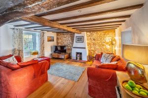 ein Wohnzimmer mit zwei Sofas und einem Fernseher in der Unterkunft Owl Cottage in Great Snoring