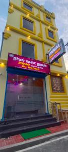 a yellow building with a sign in front of it at Nirmal Guest House in Marakkānam