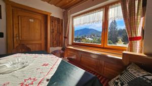 Arber Haus Paula في بايريش أيزنشتاين: غرفة نوم بها سرير ونافذة كبيرة