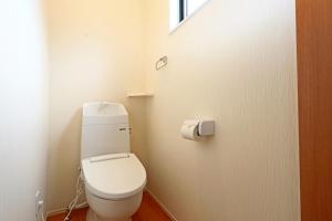 een wit toilet in een badkamer met een raam bij コテージ鎌倉 in Fujikawaguchiko +1 foto