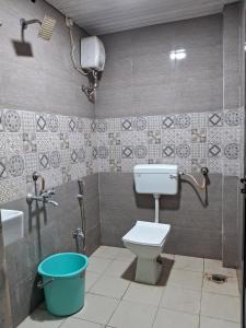 y baño con aseo, lavamanos y cubo. en Best and biggest place to have quality time, en Malavli