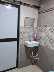 un baño con lavabo y espejo en Best and biggest place to have quality time, en Malavli