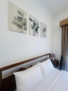 a bedroom with a bed with three pictures on the wall at Casa Santorini Negombo Resort Apartment in Negombo +8 photos