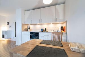 een keuken met witte kasten en een houten tafel bij Ruhige See in Borkum +2 foto's