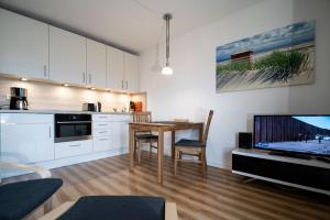 een keuken met een tafel en een tv in een kamer bij Ruhige See in Borkum