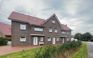 een groot bakstenen huis met witte ramen aan een straat bij Ferienhaus Auszeit in Borkum
