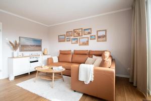 a living room with a brown couch and a table at fien un moje in Borkum