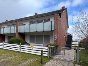 a house with a white fence in front of it at fien un moje in Borkum