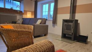 ein Wohnzimmer mit einem TV, einem Sofa und einem Herd in der Unterkunft Ferienwohnung Aschenbrenner in Hohenwarth