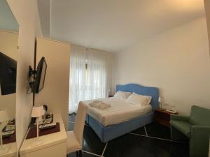 Un dormitorio con una cama, un sofá y una silla. en Sleep Al 25, en Finale Ligure