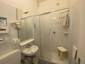 Un baño blanco con lavabo y ducha. en Sleep Al 25, en Finale Ligure