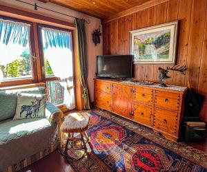 a living room with a couch and a flat screen tv at Nido Ampezzano - a short walk from the center in Cortina dʼAmpezzo