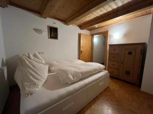 a small bedroom with a bed with white sheets at Wöscherhof in Unterahrnbach +9 photos