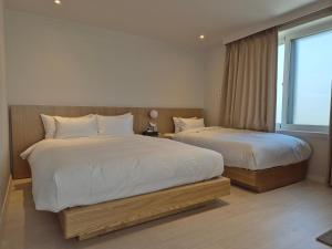 a bedroom with two beds and a window at Hotel Boreum in Sach'ŏnjil-li
