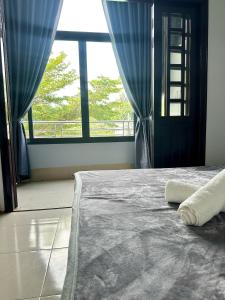 ein Schlafzimmer mit einem Bett und einem großen Fenster in der Unterkunft Nhà Nghỉ Đăng Khoa in Ấp Thiện Sơn