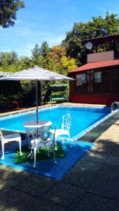 a pool with a table and two chairs and an umbrella at Judit nyaraló in Velence