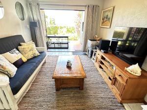 a living room with a couch and a coffee table at No. 1 Arrowood, Plettenberg Bay in Plettenberg Bay