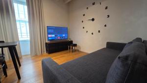 a living room with a couch and a flat screen tv at BG Time in Bergamo