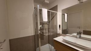 a bathroom with a glass shower and a sink at BG Time in Bergamo