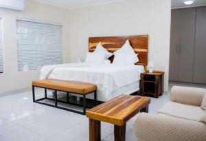 1 dormitorio con 1 cama blanca grande y 2 sillas en Wildlife Oasis, en Marloth Park