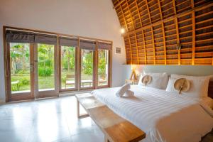 Kayu Jati Cottages في Toyapakeh: غرفة نوم بسرير ابيض كبير مع طاولة