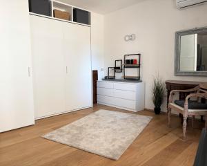 Habitación con armarios blancos, mesa y espejo. en Bilocale centralissimo a due passi dal mare - CN023, en Cesenatico 14 fotos más
