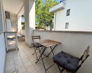 Un patio con una mesa y sillas en un balcón. en Bilocale centralissimo a due passi dal mare - CN023, en Cesenatico