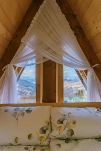 een bed in een kamer met een raam bij Komovi Luxury Sunset in Andrijevica