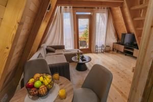 een woonkamer met een bank en een tafel met een fruitschaal bij Komovi Luxury Sunset in Andrijevica