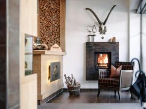 a living room with a chair and a fire place at Alpinhotel Monte Superior - Silvretta Card Premium Betrieb in Galtür