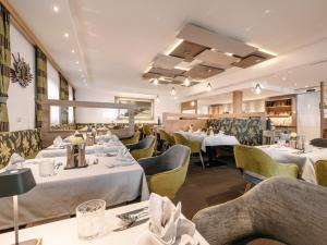 a restaurant with white tables and yellow chairs at Alpinhotel Monte Superior - Silvretta Card Premium Betrieb in Galtür +189 photos