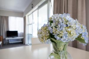 a vase filled with white and yellow flowers on a table at Sea Breeze On Belt - near beach & coastal walk in New Plymouth