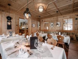 a restaurant with white tables and chairs and lights at Alpinhotel Monte Superior - Silvretta Card Premium Betrieb in Galtür