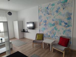 a room with two chairs and a map on the wall at Apartman Centar Surcin in Surčin