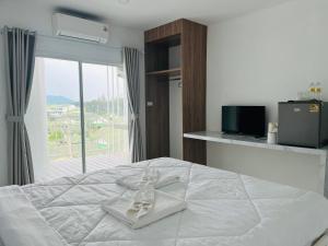 SattahipにあるDm สัตหีบ อู่ตะเภา สนามกีฬาราชนาวีสัตหีบの白いベッド(靴1足付)