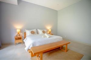 Kayu Jati Cottages في Toyapakeh: غرفة نوم بها سرير أبيض كبير مع مصباحين