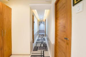 a hallway with black and white tile flooring and wooden doors at FabHotel Regal Inn - In Sahar Road in Mumbai
