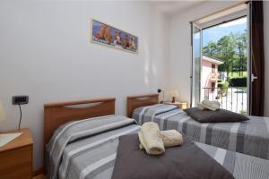 two beds in a room with a window at Viola in Colico