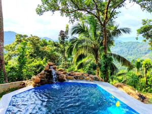 a swimming pool in a resort with a waterfall at Dhunhill Garden in Avissawella