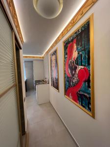 a hallway with paintings on the walls of a house at Central Park Rentals in Chişinău