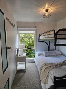een slaapkamer met een stapelbed en een raam bij Port Sorell Beach Shack in Port Sorell +9 foto's