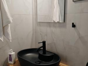 lavabo negro en el baño con espejo en Olympic Flame Suites, en Pyrgos 18 fotos más