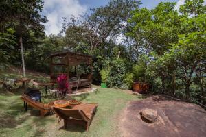 a garden with benches and a gazebo at Teepee - Tipi da Serra in Brumadinho