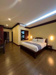 a bedroom with a large bed in a room at Pon Arena Hotel in Muang Không